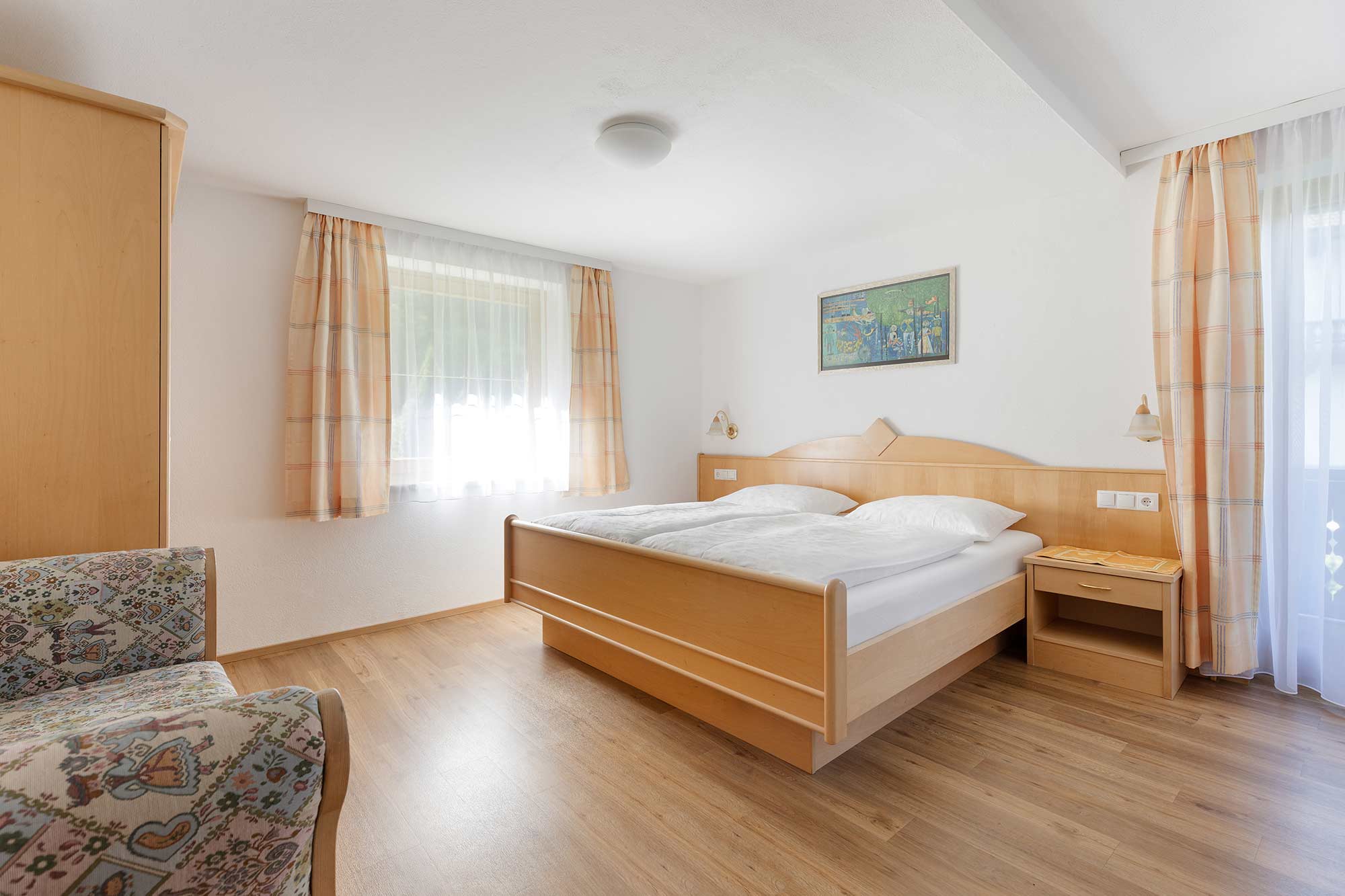 Schlafzimmer 1 mit  Doppelbett und Blick auf Wiesen, Wald und Berge
